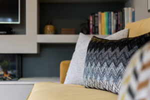 textured black, blue and white cushions on a mustard sofa