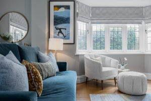 refurbished family living room with blue sofa and white armchair and footstool